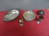 trois assiettes et tasses plaquées argent posées sur une nappe rouge