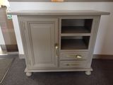 a small cabinet with a door and a shelf on top of it