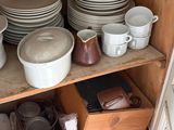 many dishes and cups on the shelves in the kitchen