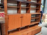 une photo d'une grande bibliothèque en bois avec des tiroirs et des étagères