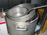 Des casseroles et des poêles sont empilées sur une étagère dans une cuisine.