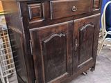 a wooden cabinet with two pictures on top of it
