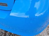a close up of a blue car ' s rear bumper