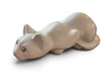a cat figurine sitting on a white surface
