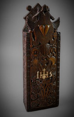 une image représentant une plaque en bois sur laquelle figurent un oiseau et une croix