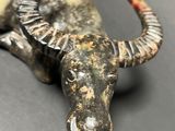 a statue of a bull laying down on a table
