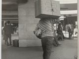 photographie en noir et blanc d'un homme portant une boîte sur la tête