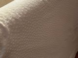 a close up of a white couch with a pillow on it