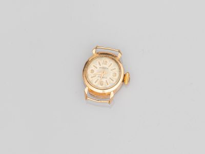 gros plan d'une montre en or sur une surface blanche