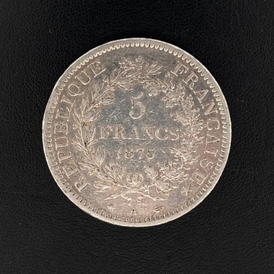 gros plan d'une pièce de monnaie en argent sur une surface noire