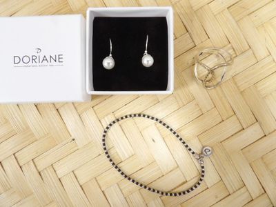 a white box with a pair of earrings and a bracelet