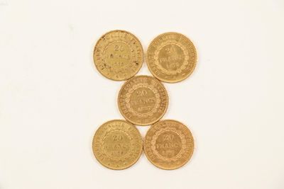 four gold coins sitting on top of each other on a white surface