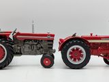 two red and white toy tractors sitting side by side on a white surface