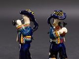 deux figurines représentant un homme et une femme jouant d'un instrument
