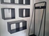 une étagère noire avec un porte-manteau et un porte-manteau fixé au mur