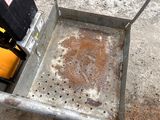 a small metal box with dirt on the ground