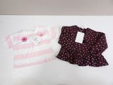 two baby clothes are sitting on a table next to each other