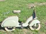 a scooter that is sitting in the grass on the ground