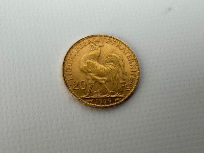 a close up of a gold coin on a white surface