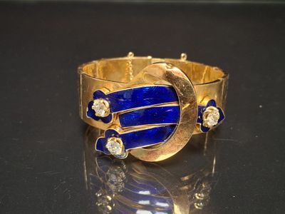 gold bracelet with lapis and diamonds on a black surface