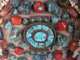 a small decorative clock made out of beads and stones