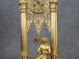 une horloge en or sur laquelle est assise une femme