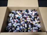 a cardboard box filled with assorted bottles of paint