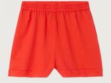 a baby boy ' s red shorts with a white logo on the side