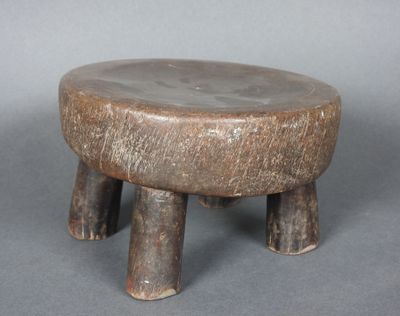 un petit tabouret en bois posé sur une table