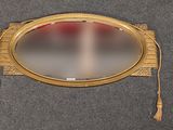 un miroir doré auquel sont suspendus des pompons