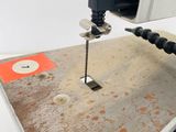 a drill that is being used to drill a hole in a piece of wood