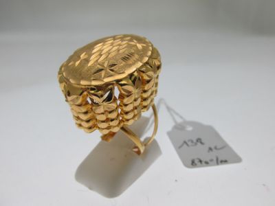 une image d'une bague en or sur une surface blanche avec une étiquette de prix