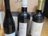 trois bouteilles de vin posées sur une table à côté d'une boîte