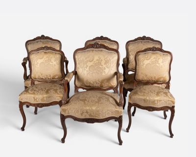 four antique chairs with upholstered arms and a gold upholstered back