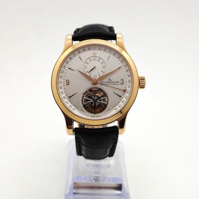 a close up of a watch with a gold case and black leather strap