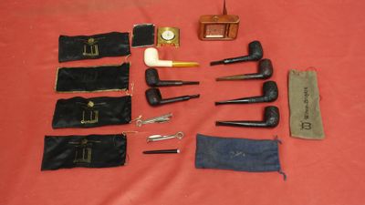 a lot of different types of smoking pipes on the table
