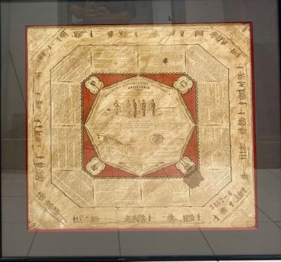 a framed picture of a gold plate with a red border in a black frame