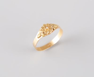 un gros plan d'une bague en or ornée de fleurs