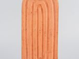 an orange ceramic sculpture of a door on a metal stand