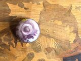 une bougie violette posée sur une table en bois