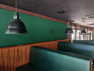 une cabine verte avec deux lampes noires suspendues au plafond