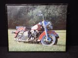 une photo d'une moto rouge garée dans l'herbe