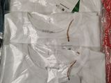 a white shirt in a plastic box with a tag on it