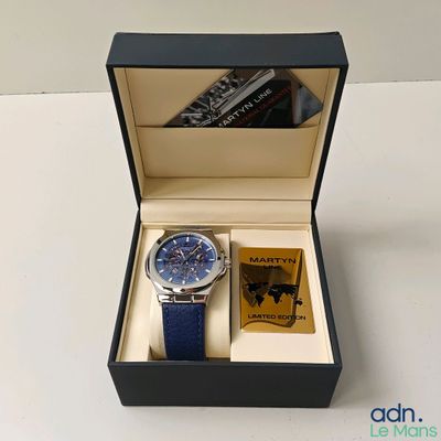 une montre dans un coffret noir, avec un bracelet bleu