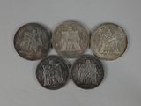 four different coins are shown on a white surface