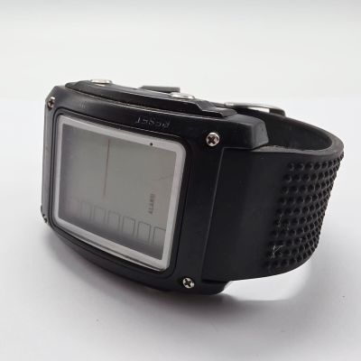 une montre numérique posée sur une surface blanche