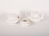 two white porcelain teapots and a bowl on a white surface