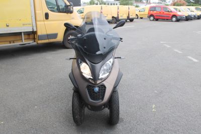 une moto garée sur un parking, avec un camion en arrière-plan