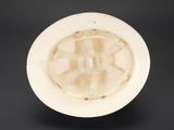 a white bowl with a hole in it on a black surface