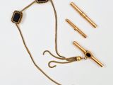 un collier en or orné d'une pierre noire et d'une chaîne en or